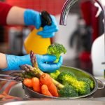 Woman washing vegetables on kitchen counter